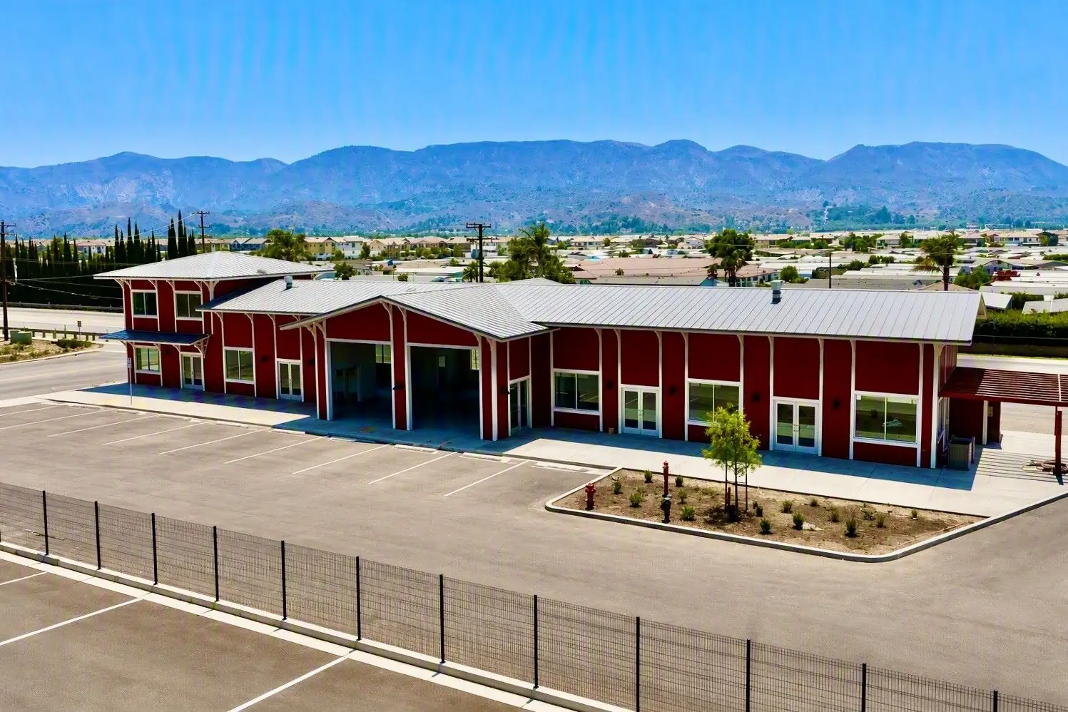Aerial view of the red two-story Highway 126 RV Storage office with the Topatopa Mountains behind in Fillmore, CA
