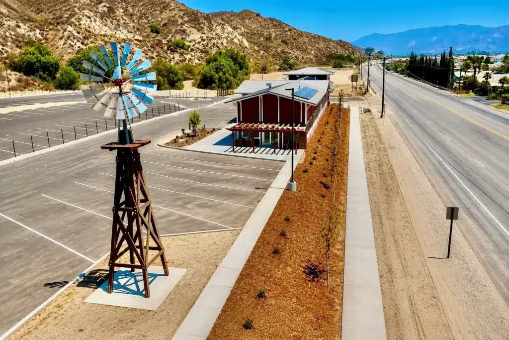 Windmill and planted frontage along Highway 126 in front of the Highway 126 RV office and paved lot