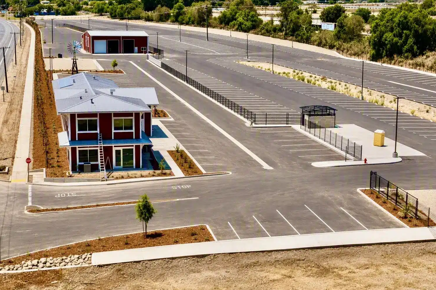 Aerial of the striped, paved RV storage lot, office and red barn at Highway 126 RV Storage — serving Valencia, CA